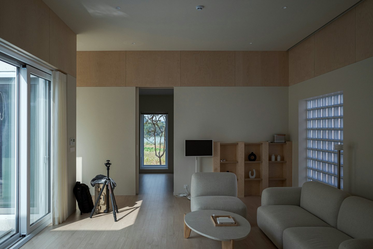 Sala de estar moderna con sofá gris y suelo de madera.